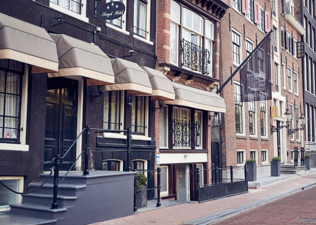 a city street with tall brick buildings and stairs at Singel Hotel Amsterdam in Amsterdam