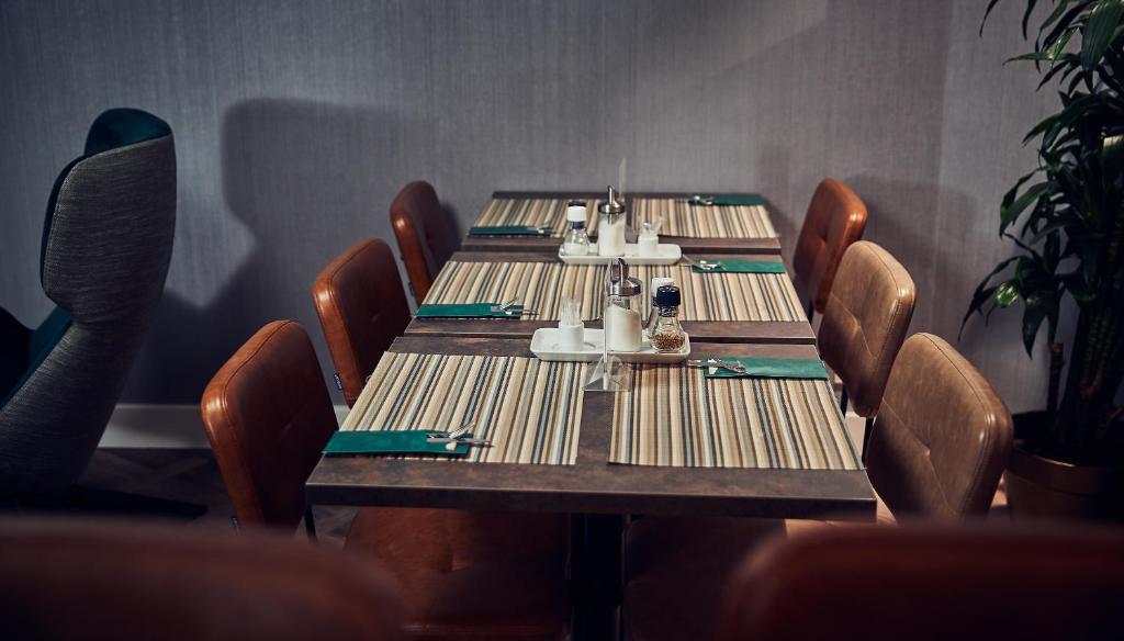 a table in a restaurant with chairs and a table set for dinner at Singel Hotel Amsterdam in Amsterdam