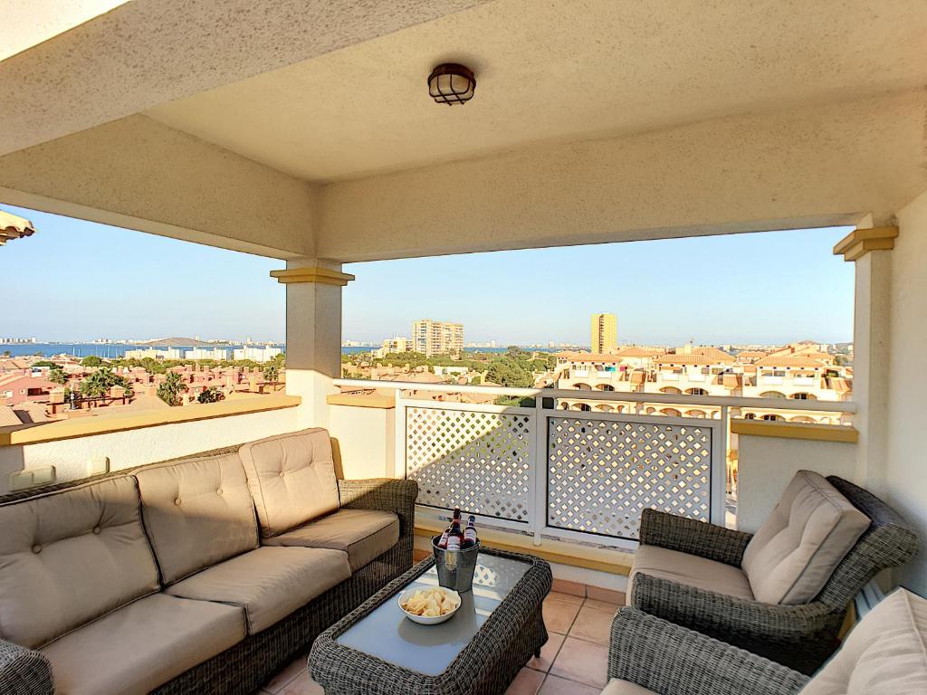 uma sala de estar com um sofá e cadeiras numa varanda em Ribera Beach 3 - 1009 em Mar de Cristal