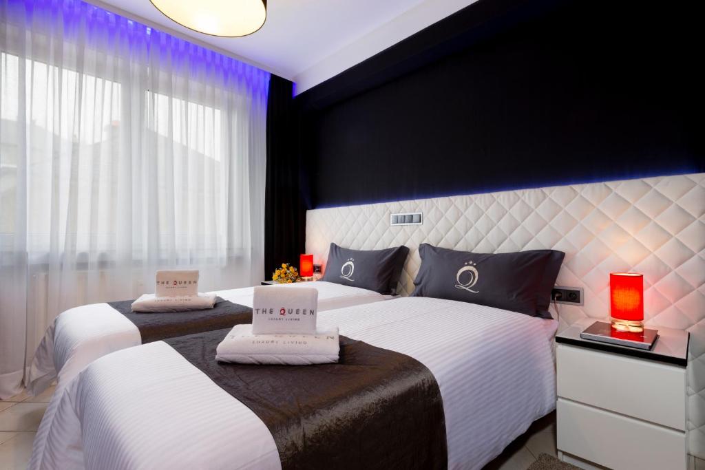 - une chambre avec 2 lits aux murs blancs et noirs dans l'établissement Villa Nakalua, à Luxembourg