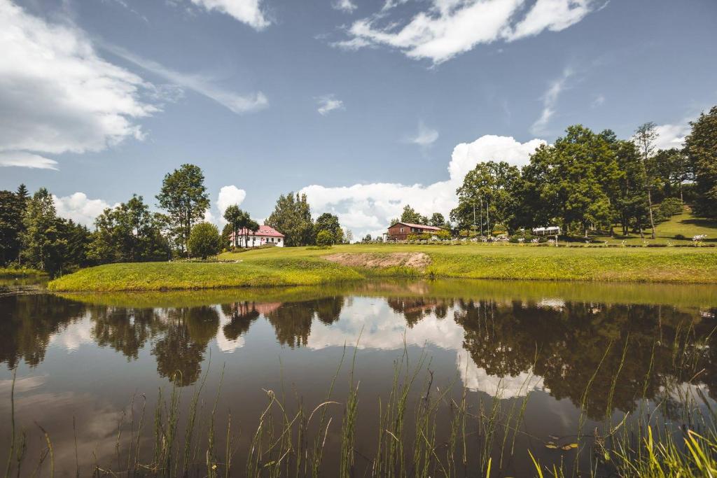 vista su un lago con una casa sullo sfondo di Šubrakkrasti a Vestiena
