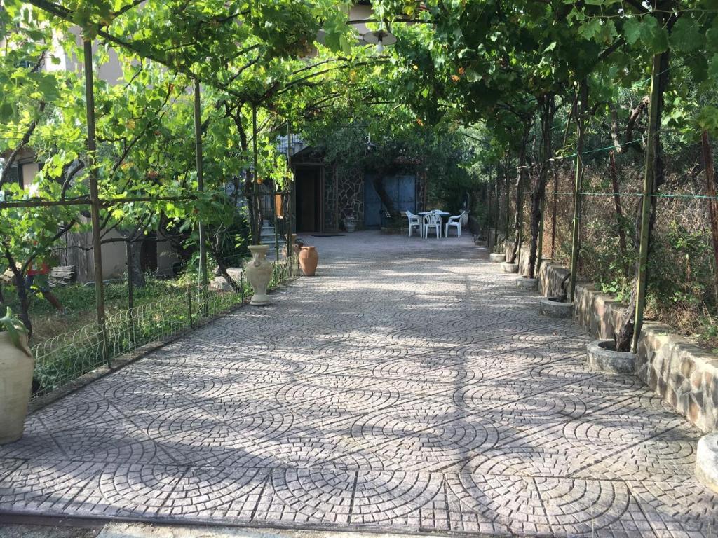einen Gehweg in einem Garten mit einem Tisch und Stühlen in der Unterkunft B&B Casa Franca in Postiglione