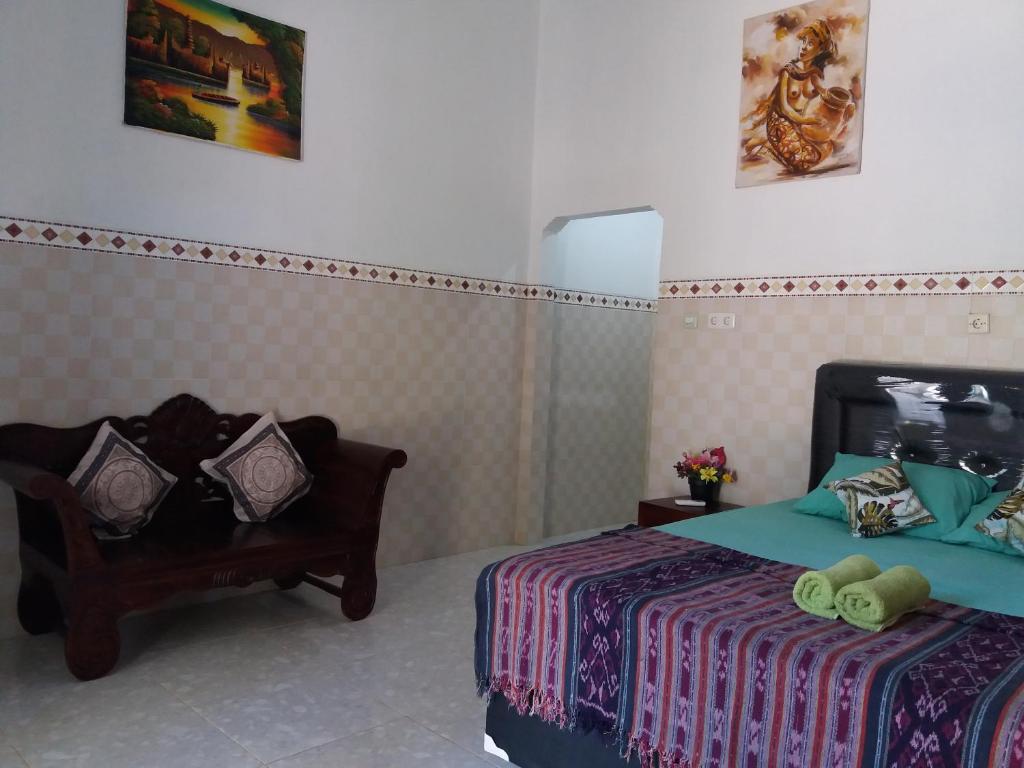een slaapkamer met een bed en een stoel bij citiz's house in Nusa Penida