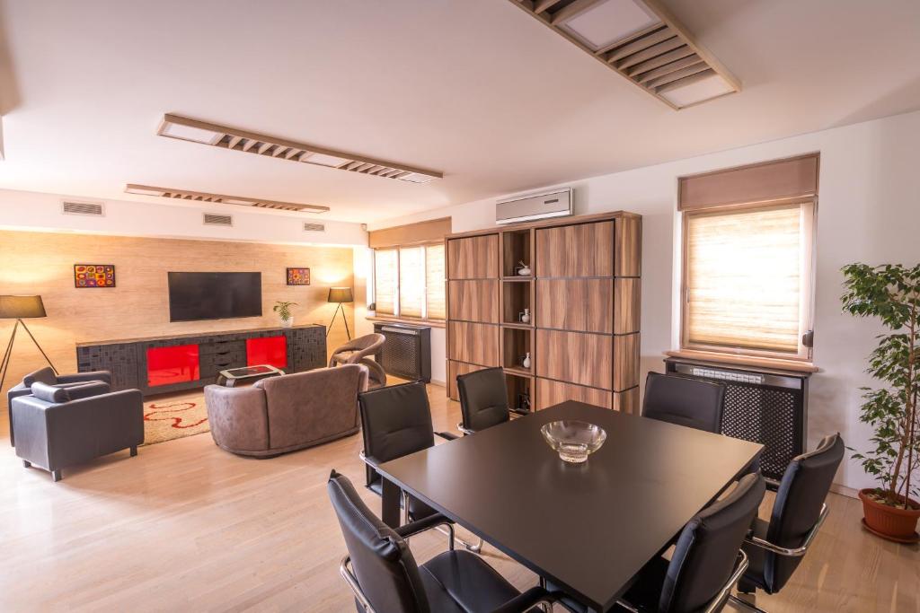 sala de estar con mesa y sillas en HostGost at BAMS (Private Spa included) en Belgrado