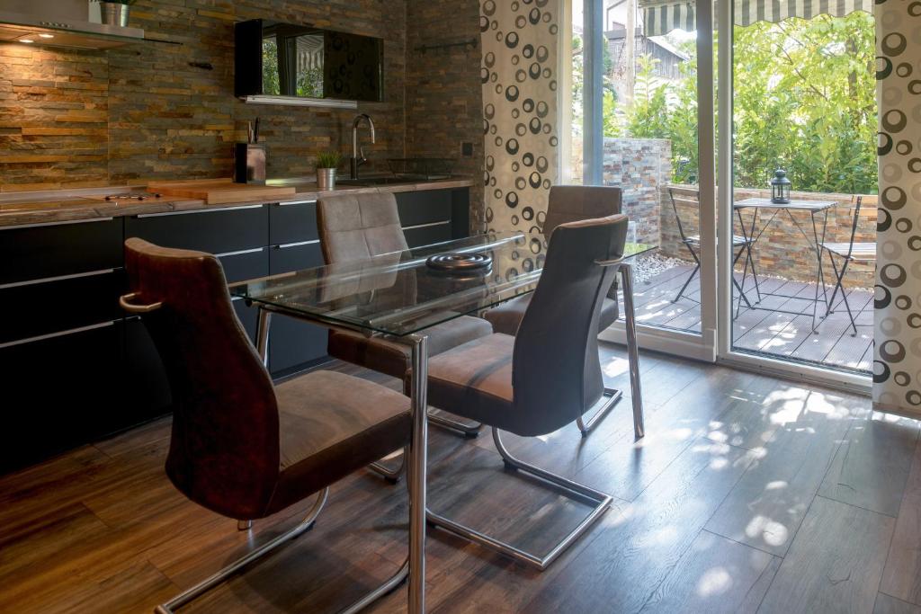 uma cozinha com uma mesa de vidro e cadeiras em Cute sunny apartment KOD1 em Liubliana