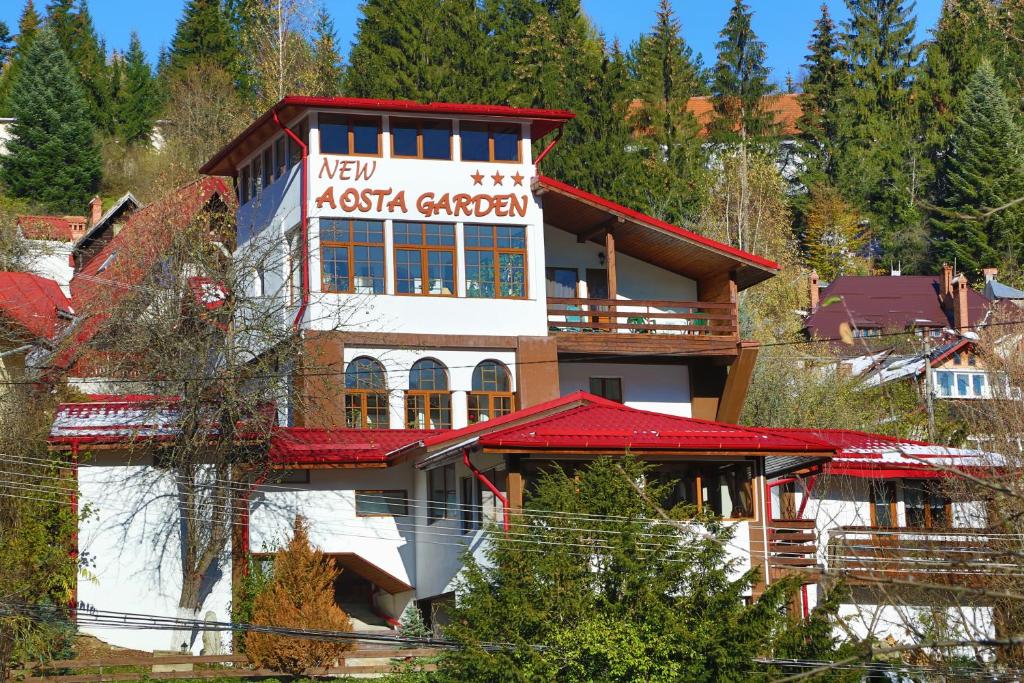 a building with a sign on the side of it at New Aosta Garden in Sinaia