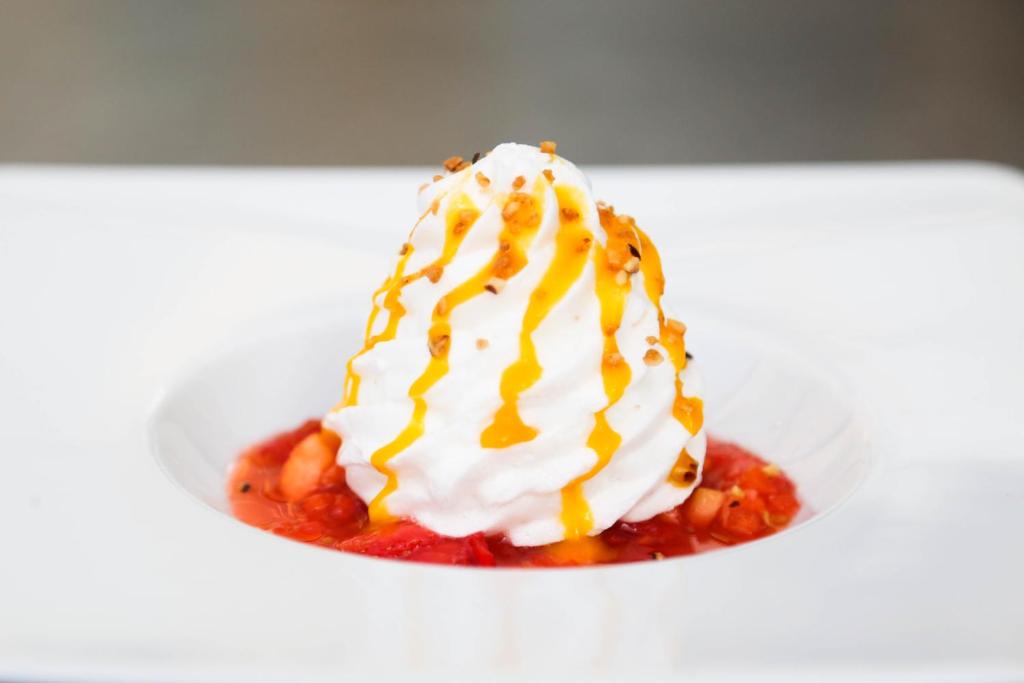 a dessert with whipped cream and sauce on a plate at Domaine Utah Beach - Le Grand Hard in Sainte-Marie-du-Mont