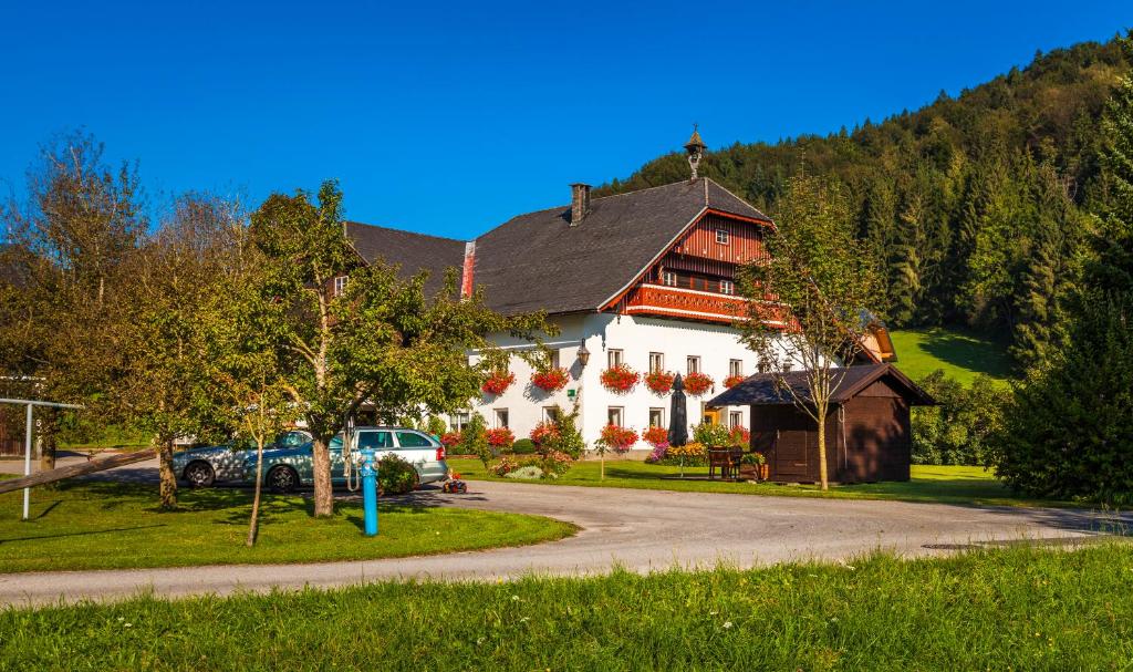 ein großes weißes Haus mit einem davor geparkt in der Unterkunft Waschlgut in Ebenau