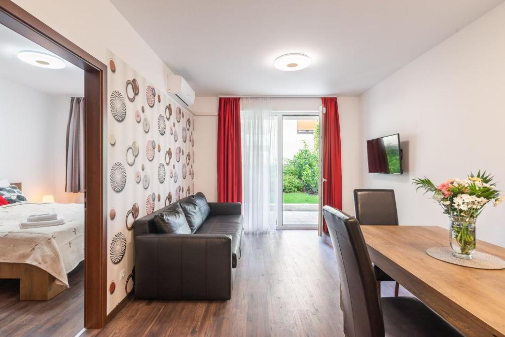 Corvin Residence Apartments في بودابست: غرفة معيشة مع طاولة وغرفة طعام