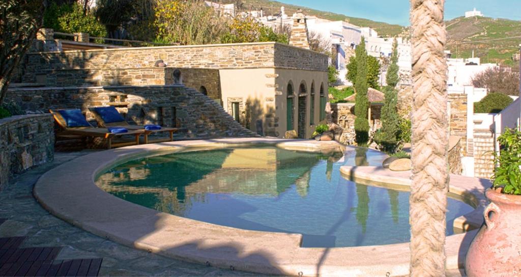 una piscina en un patio con sillas y una casa en Villa Tripotamos, en Tripótamos