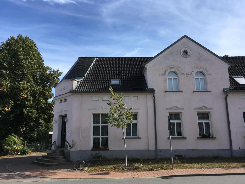 una casa bianca con un albero davanti di Storchenblick a Straupitz