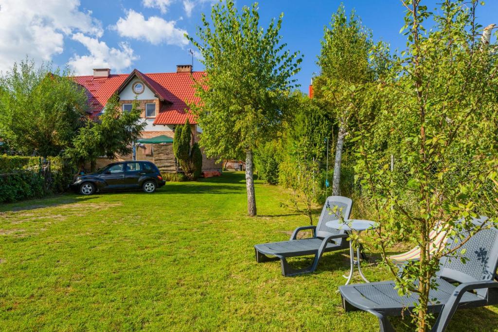 a yard with two chairs and a table and a car at MORSKIE KĄTY - w otoczeniu przyrody Zalewu Wiślanego, spacerem do morza, DOG-friendly in Kąty Rybackie