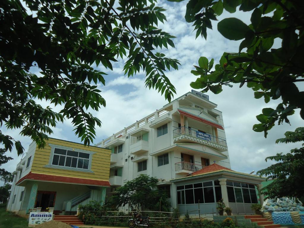 ein weißes Gebäude mit Balkon darüber in der Unterkunft Aruvi Hotel in Yelagiri