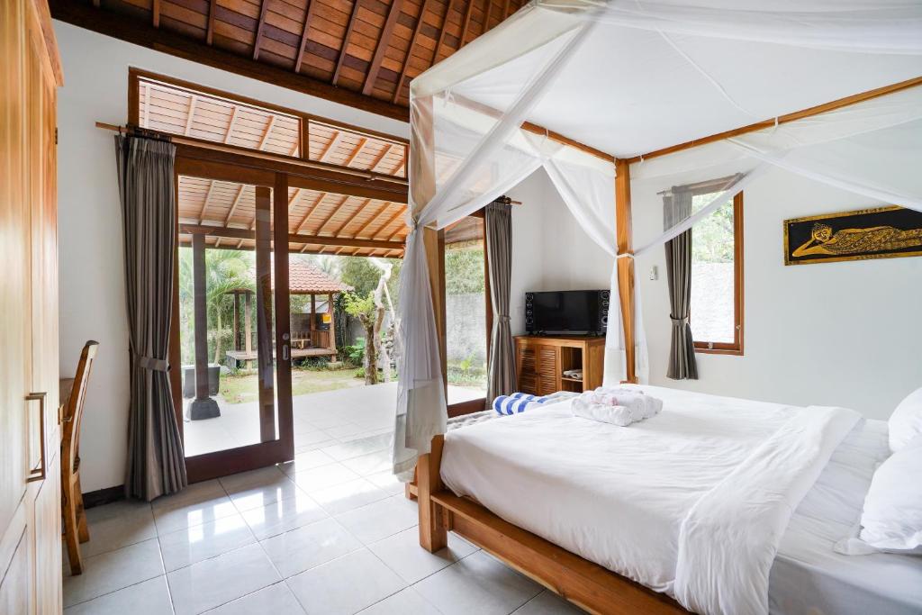 a bedroom with a bed and a tv in it at Sunny Sun Ubud Private Villa in Ubud