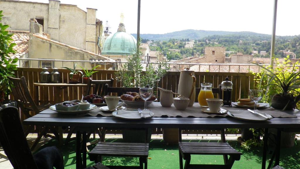 einen Tisch mit Tellern aus Essen auf einem Balkon in der Unterkunft L'Auberge Espagnole - Bed & Breakfast in Apt