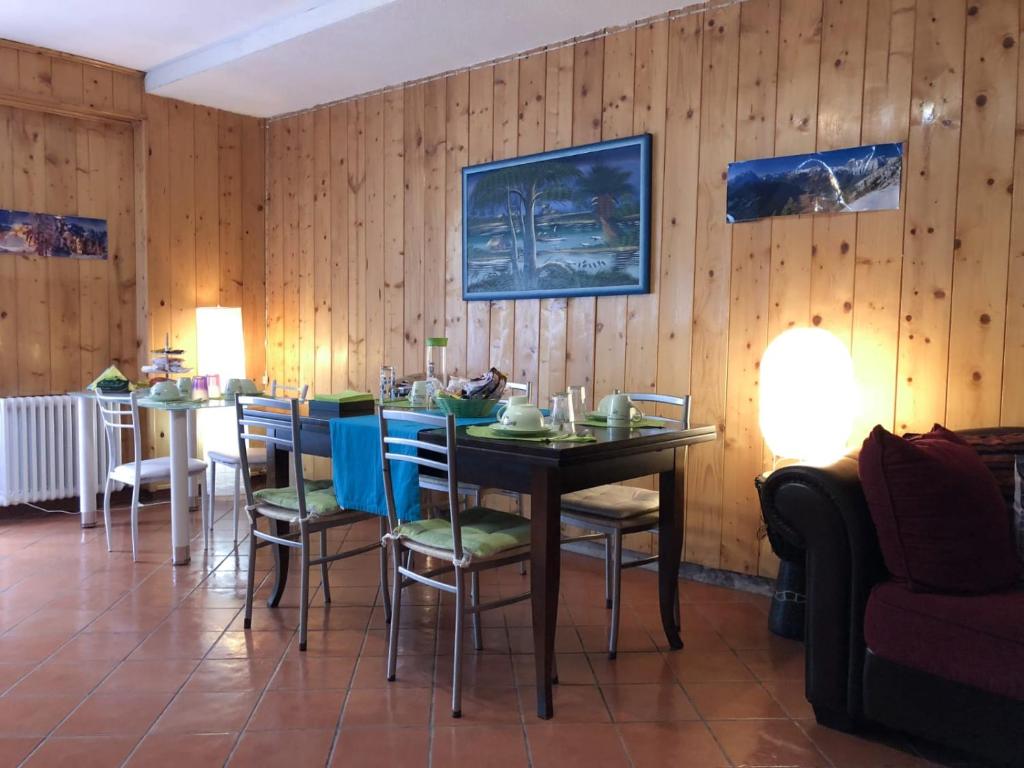 a dining room with a table and chairs and wooden walls at Central Greenlife in Tarvisio