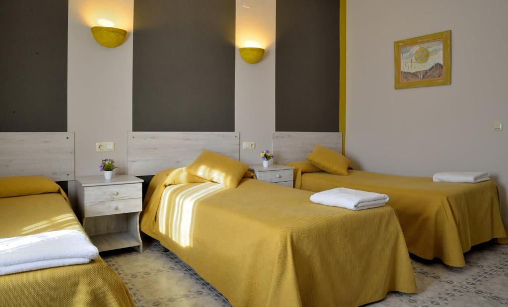 a room with two beds with yellow sheets at Cuatro Caminos in Piedrabuena