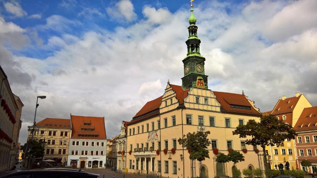 um edifício com uma torre de relógio em cima em Apartments SMAG Barbiergasse em Pirna