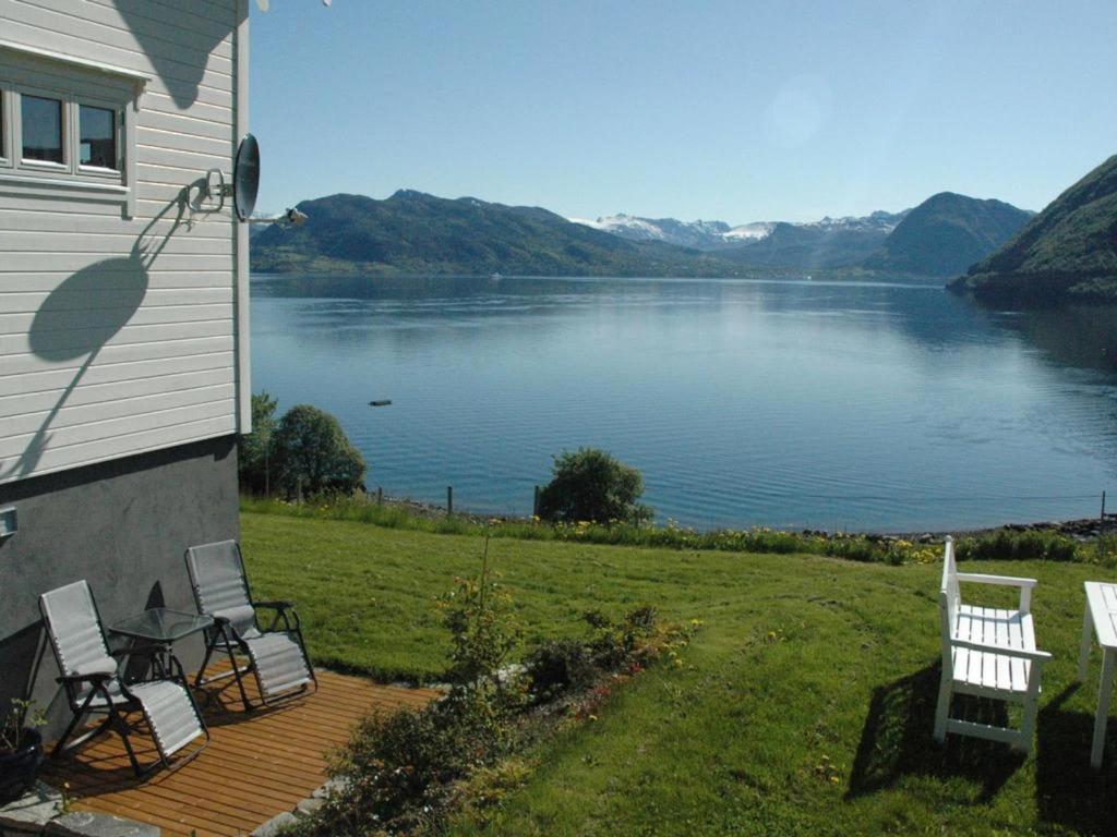 a house with chairs and a view of a lake at Irenegarden - Panorama apartment in Lauvstad