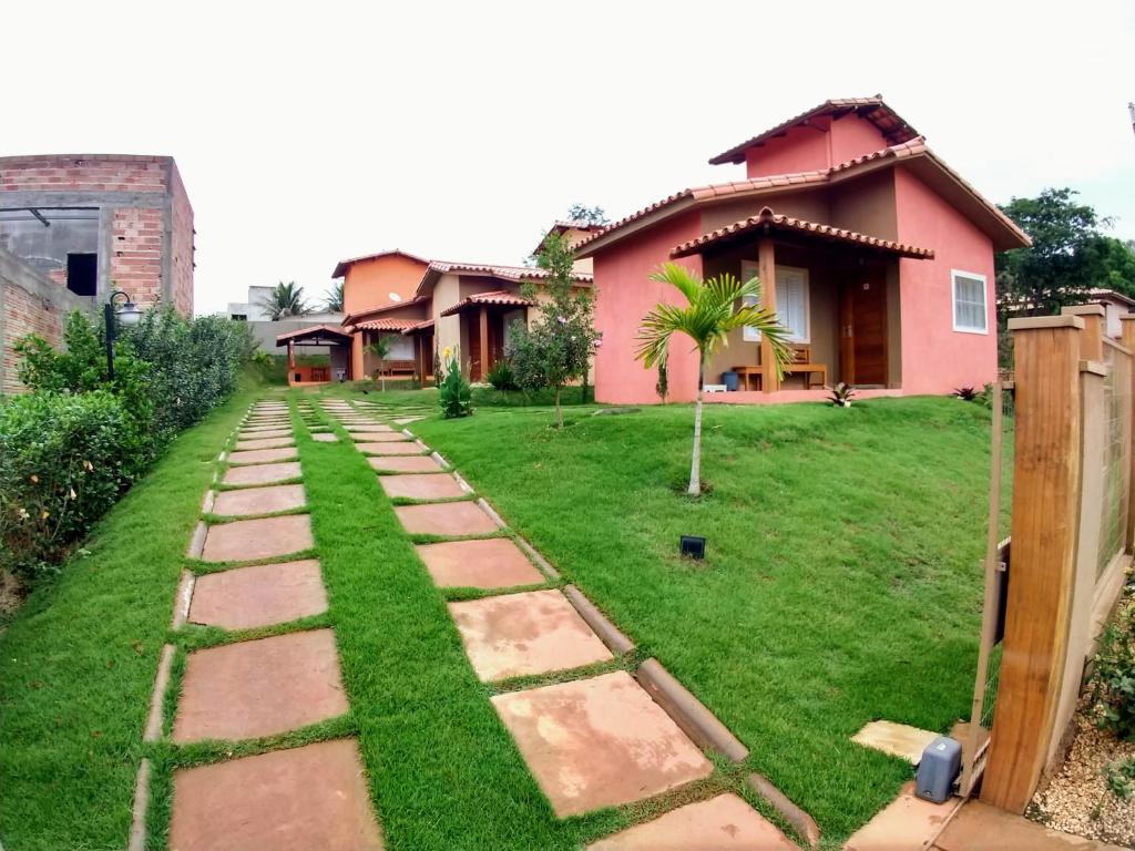 um jardim com um caminho em frente a uma casa em Chalés Capitólio em Capitólio