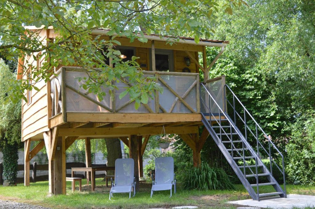ein Baumhaus mit einer Treppe, die hinauf führt in der Unterkunft LES GITES INSOLITES DE LA CASCADE in Lespesses