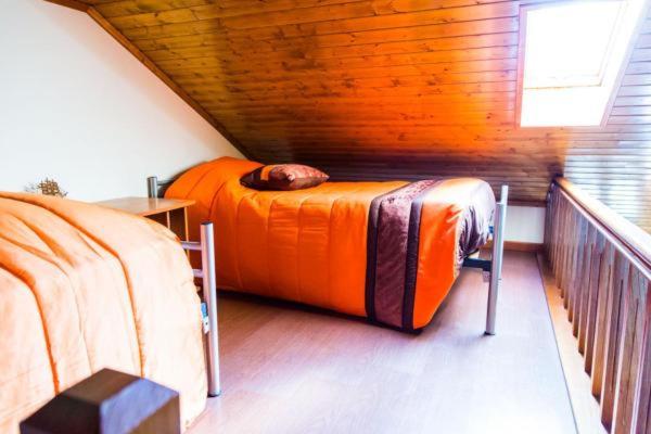 a bedroom with an orange bed in a attic at "Casa Da Russa" Mountain Experience in Vila Real