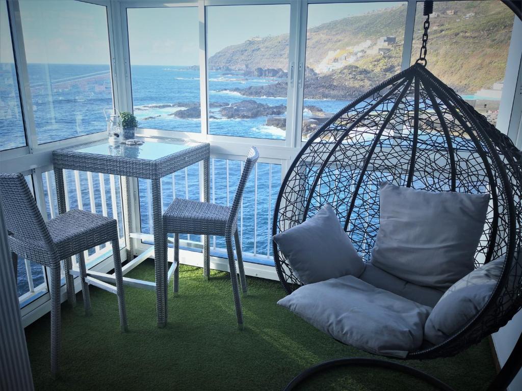 a swing in a room with a table and chairs at Apartment on the sea in Puerto de la Madera