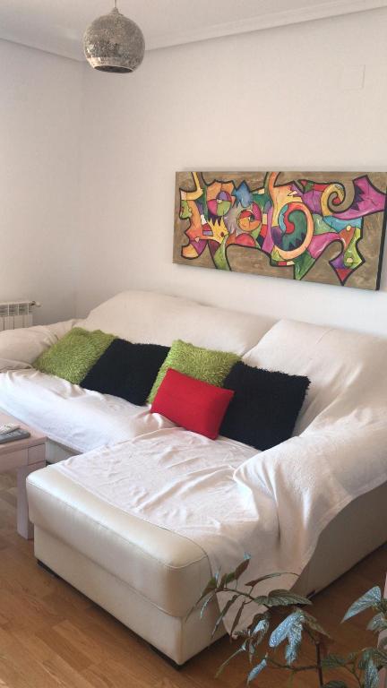 クエンカにあるCalidad y Armoníaの壁画のある部屋の白いベッド1台