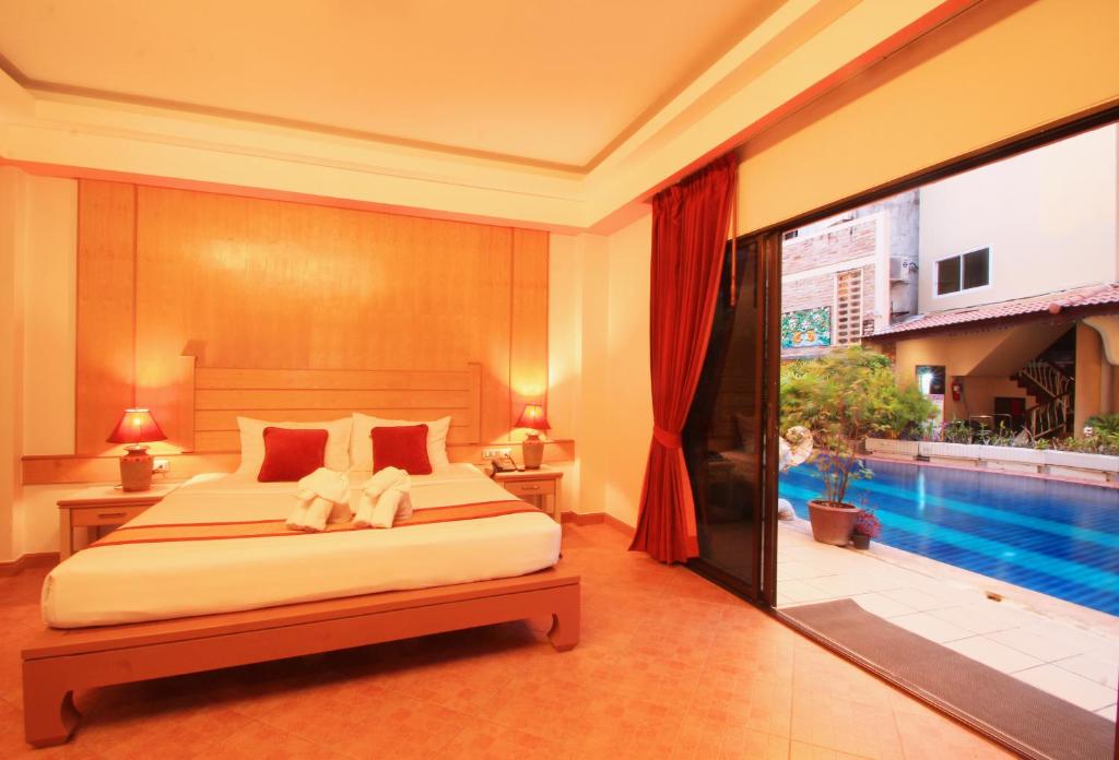 a bedroom with a bed and a swimming pool at Baan Boa Resort in Patong Beach