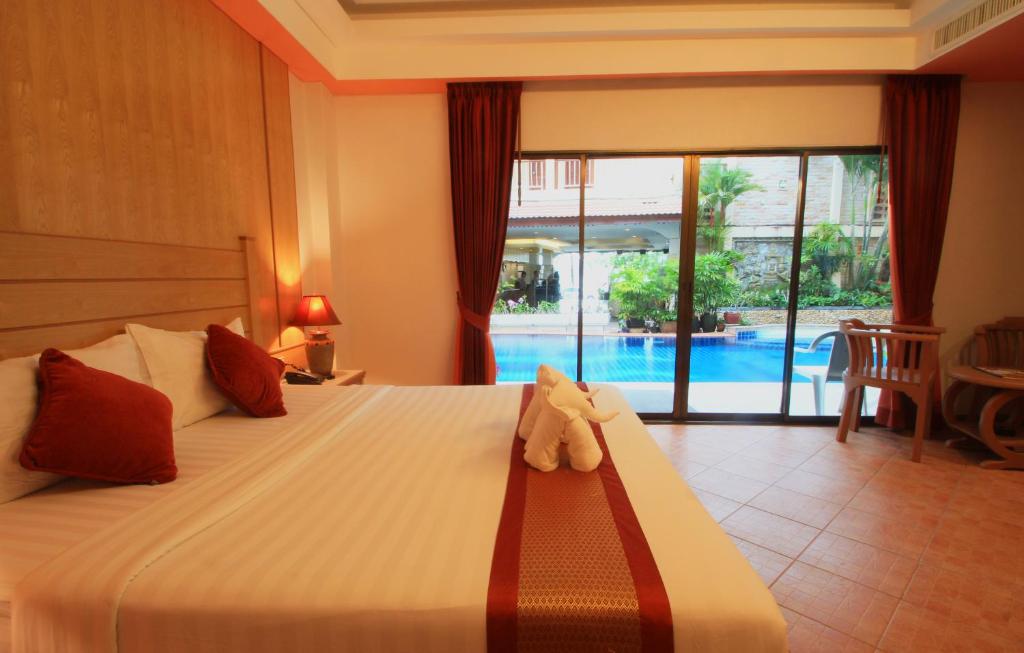 a bedroom with a bed with a teddy bear on it at Baan Boa Resort in Patong Beach