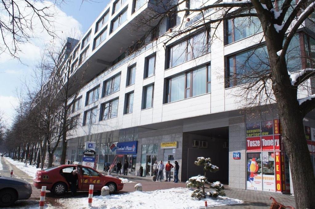 budynek z samochodem zaparkowanym przed nim w obiekcie Apartamenty Triston Park w Warszawie