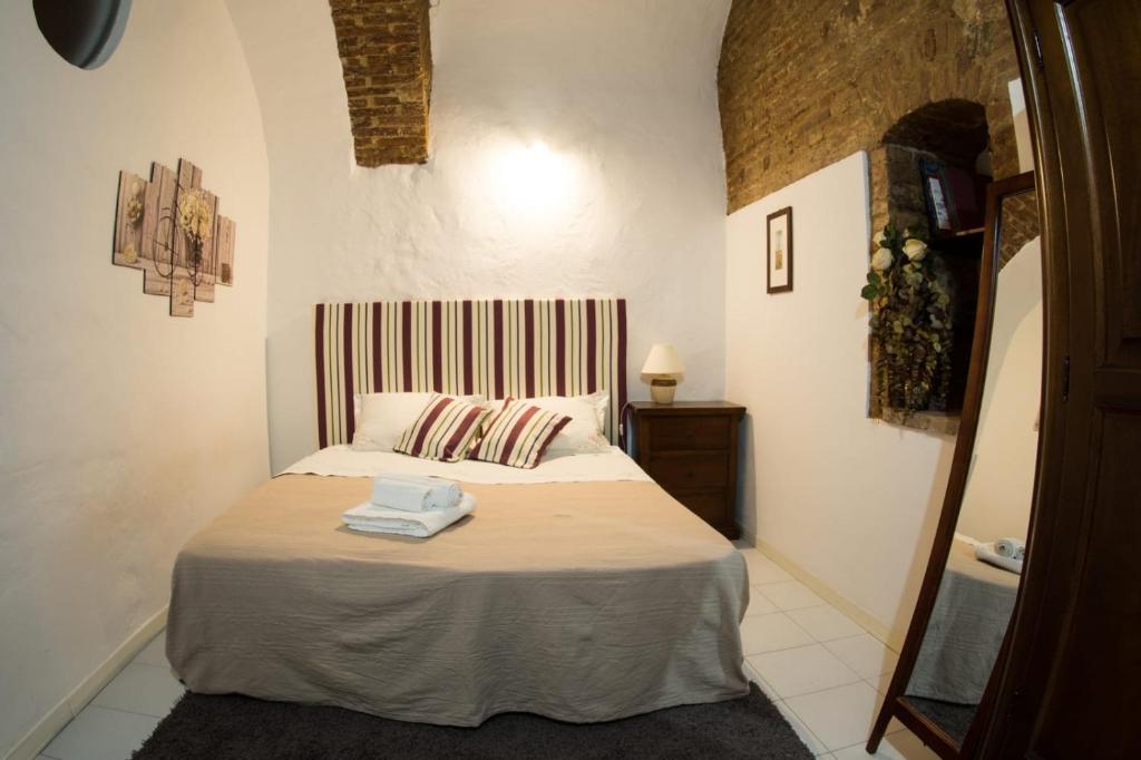 a bedroom with a bed and a mirror at Residenza d'Epoca " Il Campo" by FrancigenaApartments in Siena