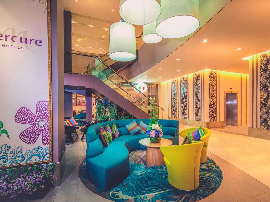 a lobby with a blue couch and a table at Mercure Kota Kinabalu City Centre in Kota Kinabalu