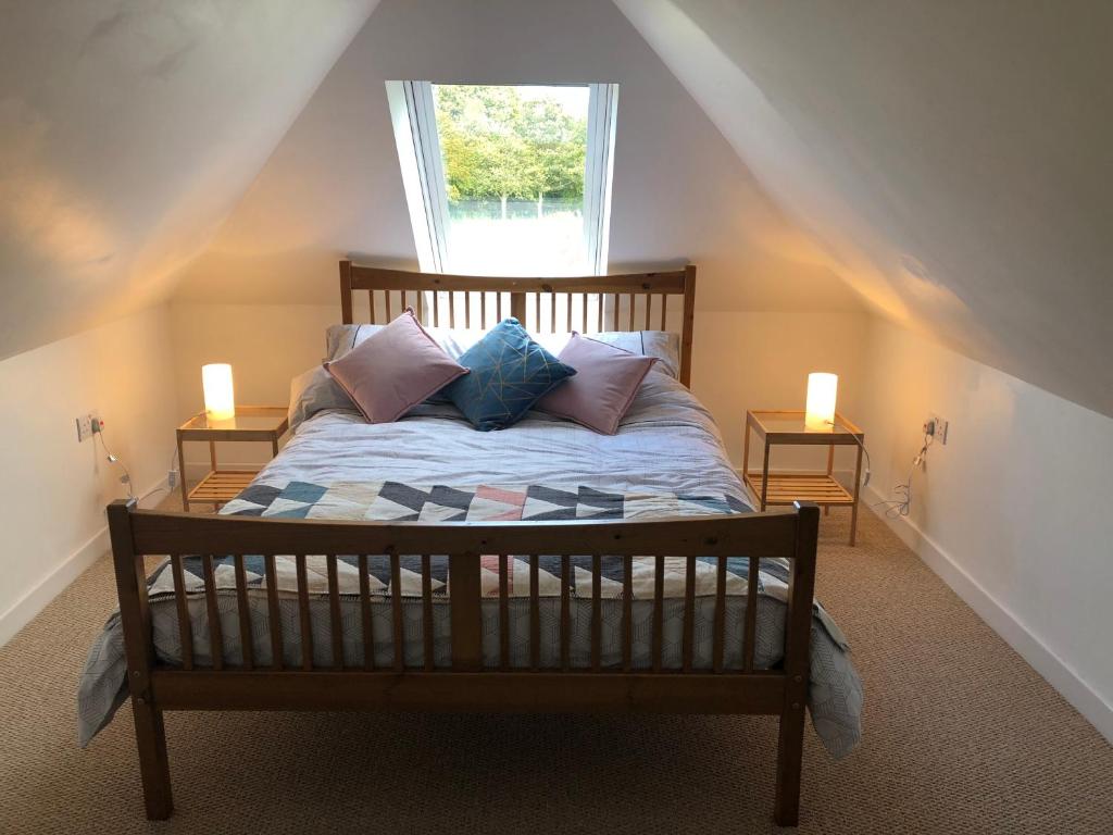 a bedroom with a bed with pillows and a window at The Grey Cottage in Blackford