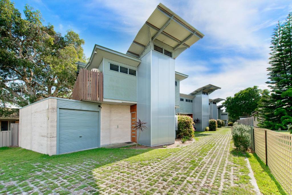 a house with a blue garage and a fence at Crescent Head Spa Villa in Crescent Head