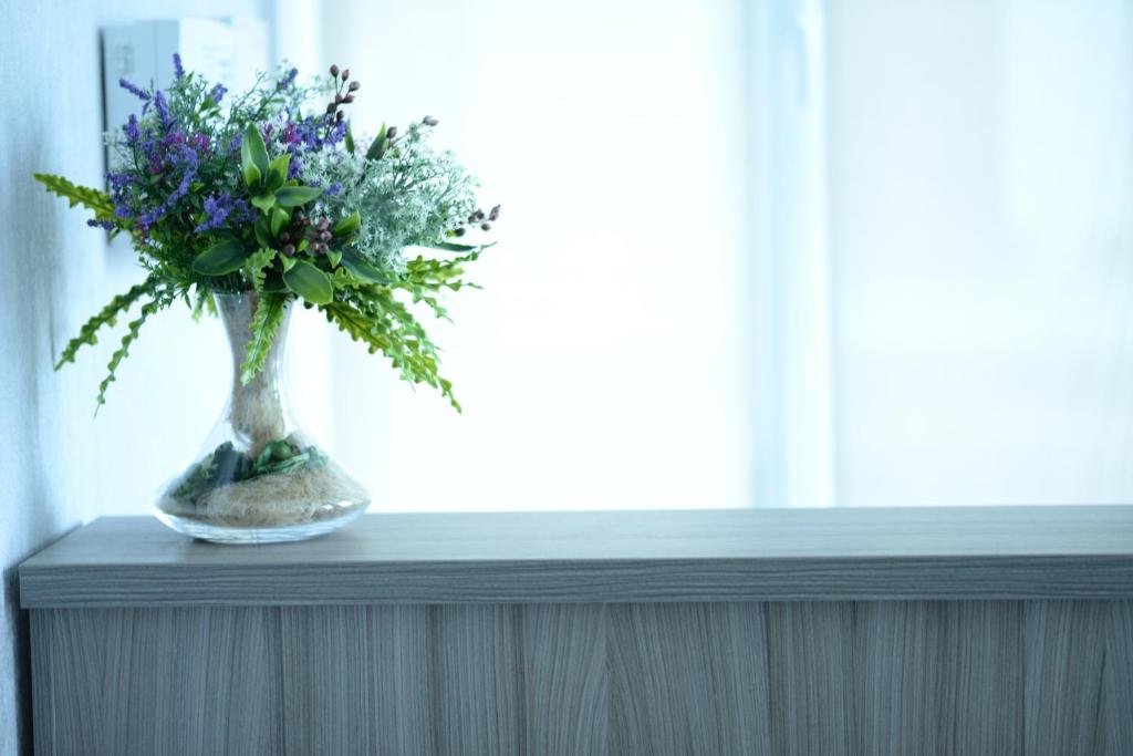 a vase filled with purple flowers sitting on a table at Apart hotel Lake Apartments in Kyiv