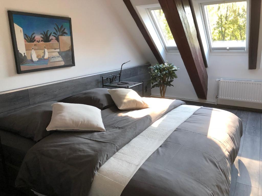ein großes Bett in einem Zimmer mit zwei Kissen darauf in der Unterkunft Engels Hof in Wolfsburg