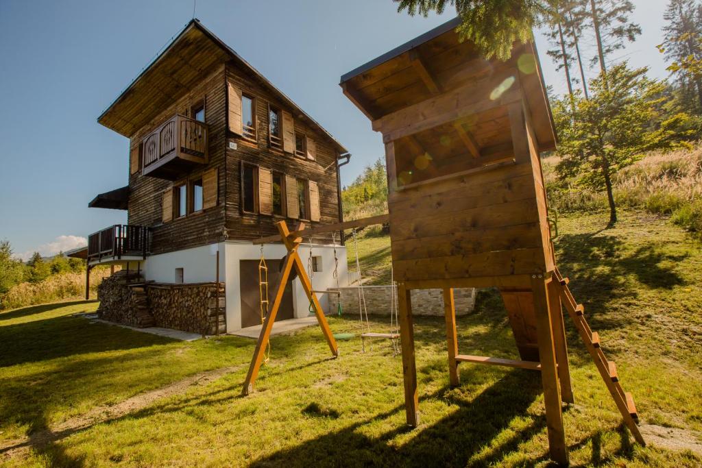 a wooden house with a sign in front of it at Chalet Veľké Ostré in Radola