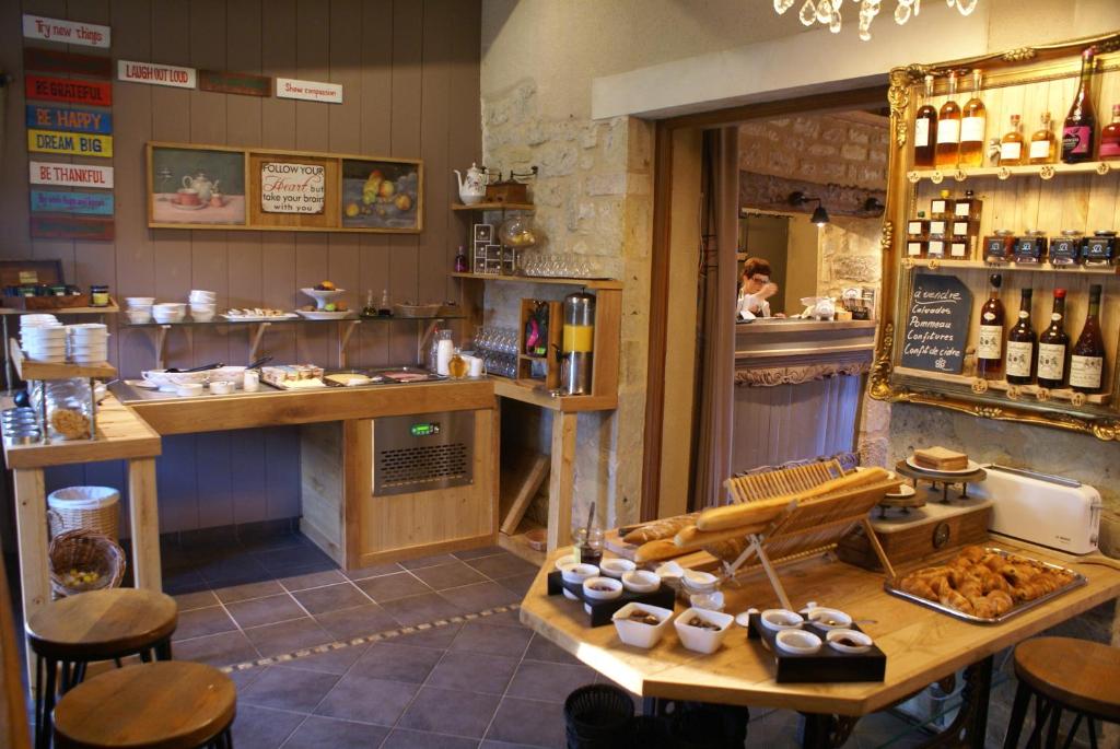 a restaurant with a counter and a table with food at Domaine Utah Beach - Le Grand Hard in Sainte-Marie-du-Mont