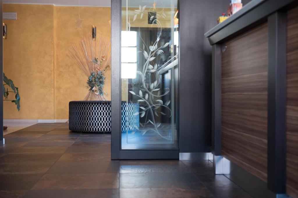 a hallway with a glass door with a vase at T'AMI Hotel Resort Spa in Selvino