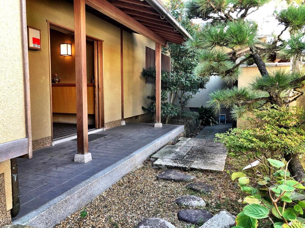une maison avec une passerelle menant à la porte d'entrée dans l'établissement 堺のお宿 旧星賀亭, à Kita-noda