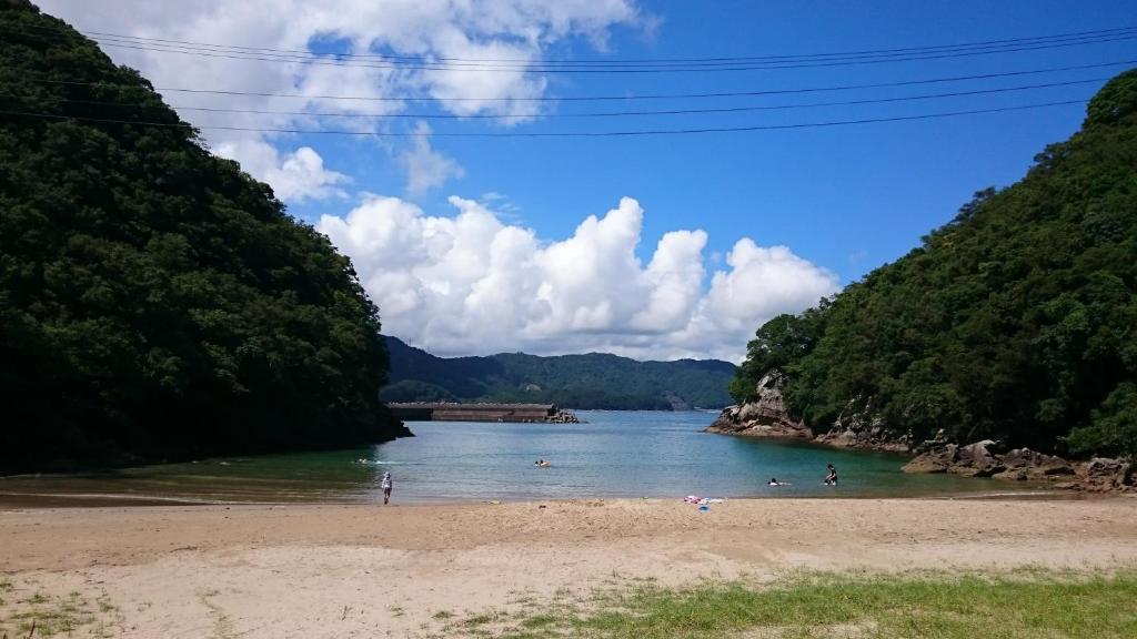 a beach with people swimming in a river at Pension Shishikui in Shishikui