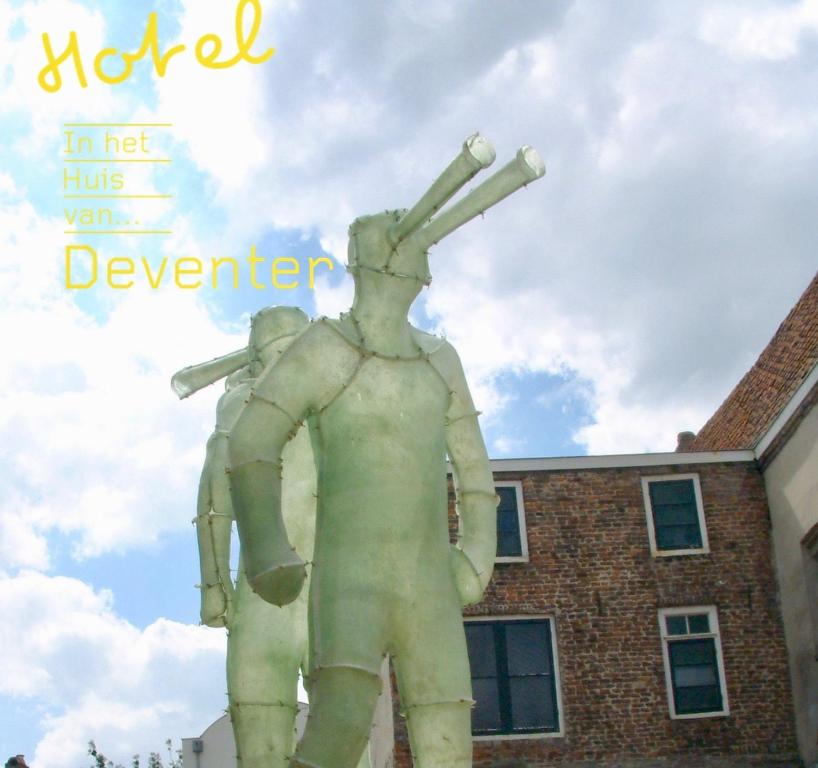 a statue of a man standing on top of a building at Hotel in het huis van Deventer in Deventer