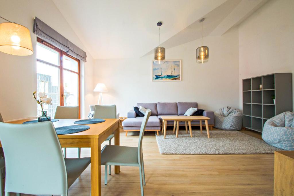 a living room with a table and a couch at Grand Apartments - Neptun Park. in Gdańsk