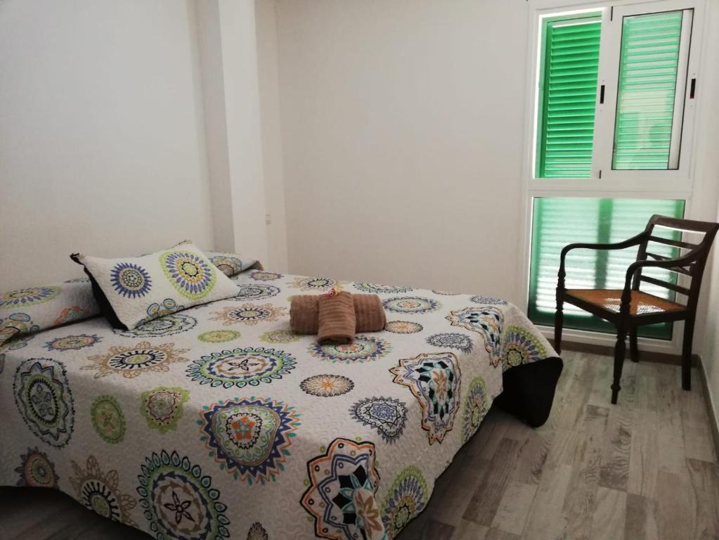プラヤ・デ・ラス・アメリカスにあるFamily Beach Apartmentのベッドルーム1室(ベッド1台、椅子、窓付)