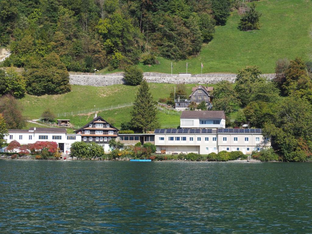 a large white building next to a large body of water at Hostel Rotschuo Jugend- und Familienferien in Gersau