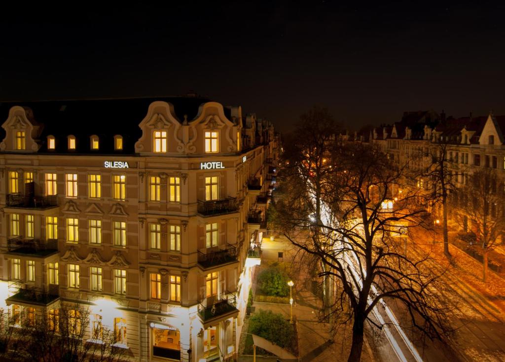 ゲルリッツにあるホテル ジレジアの夜の照明付きの建物の景色