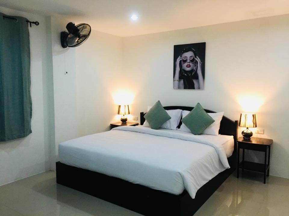 una camera da letto con un grande letto bianco con due lampade di Baba Guest House a Kamala Beach