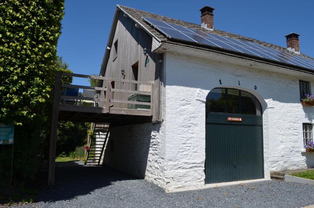 a building with a green door and a balcony at Gîte O l'Hore in Malmedy