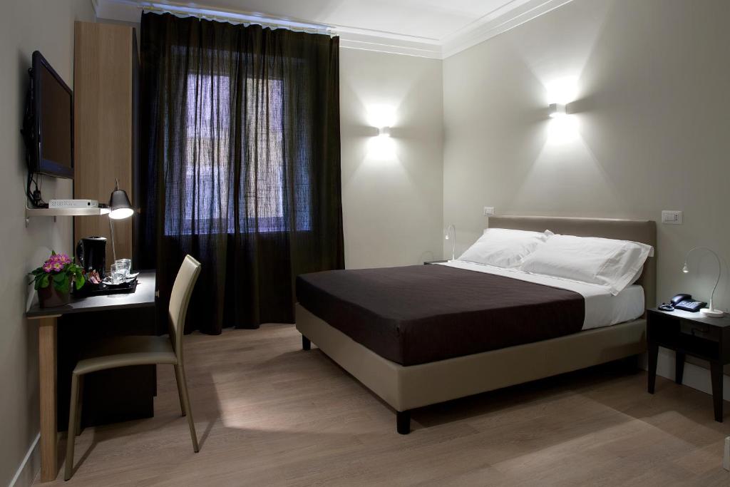 1 dormitorio con cama, escritorio y ventana en Regola Suite, en Roma